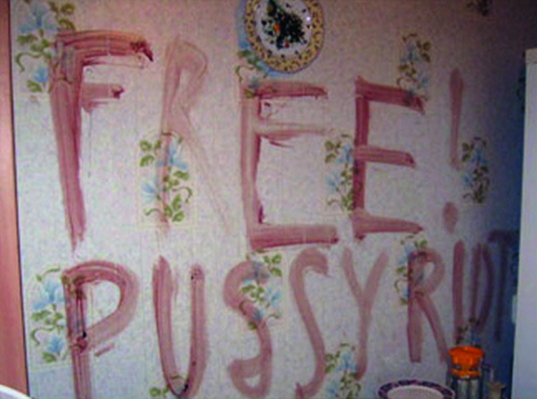 This image taken from TV footage provided by The Associated Press Television News shows a place where two women stabbed to death were found under this sign on the wall of their apartment in the central Russian city of Kazan on Thursday, Aug. 30, 2012. The sign is presumably written with blood, prosecutors said adding that the murderer probably tried to mislead police by the writing that supports three members of the provocative feminist band jailed for their 