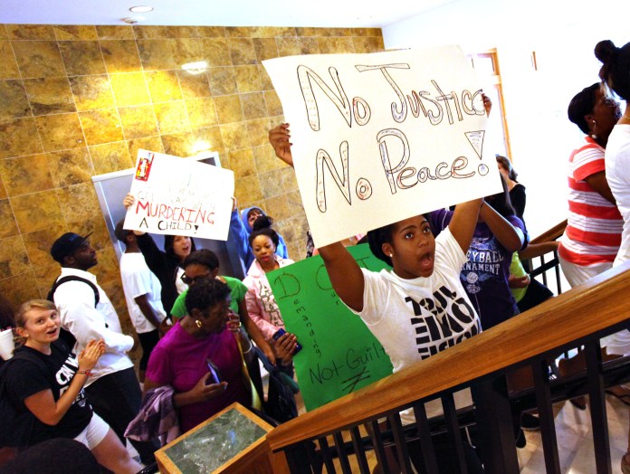 People from the local community, members of the Dream Defenders at University of Florida and other social groups march up the stairs to the local Department of Justice office in the Commerce Building, after a march from the Bo Diddley Downtown Community Plaza to the Department of Justice, Monday, July 15, demanding that the Justice Department file charges against George Zimmerman. (AP/The Gainesville Sun, Brad McClenny)