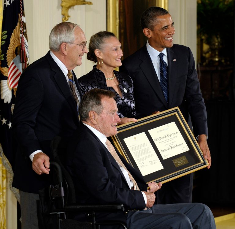 President Obama, right, and former President George H. W. Bush, seated, pose for a photograph after presenting the 5,000th Daily Point of Light Award to Floyd Hammer and Kathy Hamilton, a retired couple and farm owners from Union, Iowa,  during a ceremony in the White House on Monday. (AP/Susan Walsh)