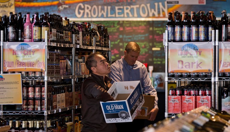 In this photo taken on Dec. 11, 2013, shoppers search for their favorite beers at Hop City Craft Beer and Wine in Birmingham, Ala. Now, in Dec. 2017, the tax reform bill states that craft brewers, distillers, and wineries will get excise taxes on their products cut for two years. (AP Photo/Dave Martin)