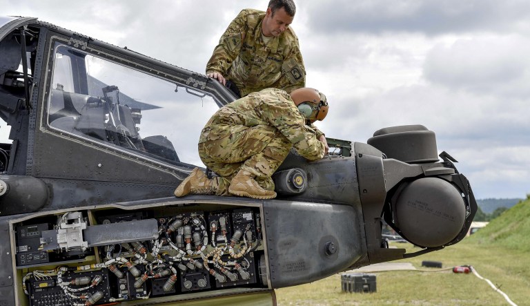 Soldiers conduct preventive maintenance checks on an AH-64D Apache Longbow helicopter during training at the Grafenwoehr Training Area in Germany, Aug. 3, 2016.