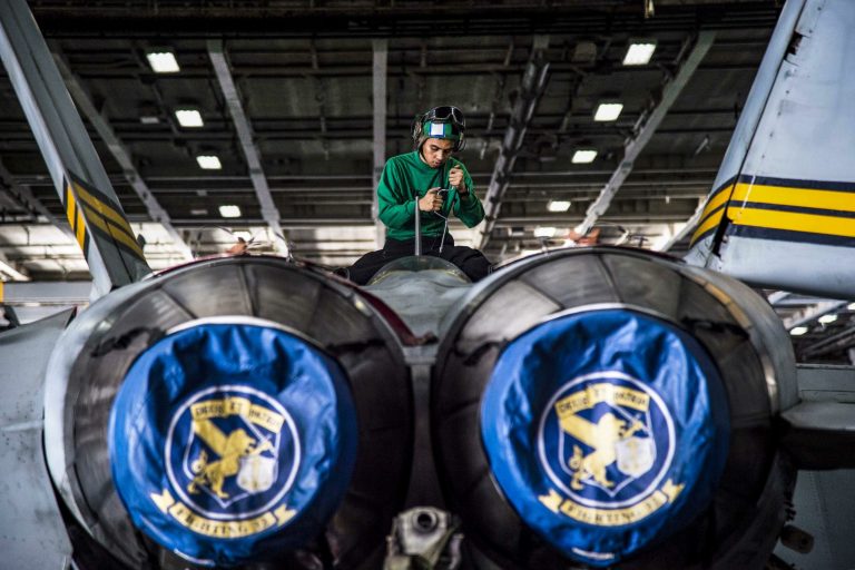 Navy Petty Officer 3rd Class Jeric Eslabra opens panels on an F/A-18F Super Hornet for a 336-day inspection in the hangar bay of the USS Dwight D. Eisenhower in the Persian Gulf, Nov. 7, 2016. 