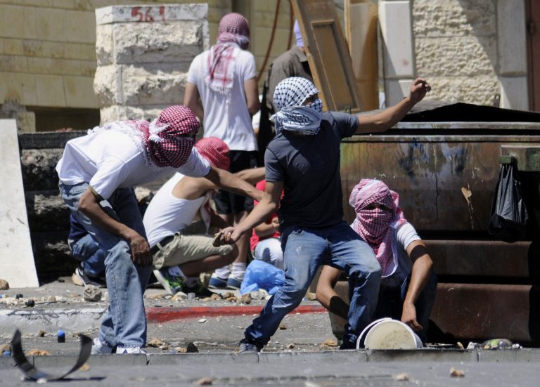 Palestinians throw stones during clashes with Israeli border police in Jerusalem on Wednesday, July 2, 2014. The suspected abduction of an Arab teen followed by the discovery of a body in Jerusalem on on Wednesday ignited clashes between Israeli police and stone-throwing Palestinians, who saw it as a revenge attack for the killing of three Israeli teens in the West Bank. (AP Photo/Mahmoud Illean)