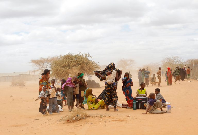   FILE - In this Friday, Aug. 5, 2011 file photo, newly arrived Somali refugees wait outside a UNHCR processing center at the Ifo refugee camp outside Dadaab, eastern Kenya, 100 kilometers (62 miles) from the Somali border. After enduring months of grenade and other explosive device attacks, Kenya has announced new, more stringent controls aimed primarily at Somali refugees inside its borders, announcing this week that all refugees and asylum seekers from Somalia must return to the refugee camp complex in northern Kenya known as Dadaab. (AP Photo/Jerome Delay, File)  