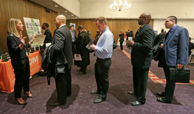A corporate recruiter speaks with job applicants during a National Career Fairs job fair in Chicago. The Labor Department releases weekly jobless claims on Thursday, May 14, 2015. (AP Photo/M. Spencer Green)