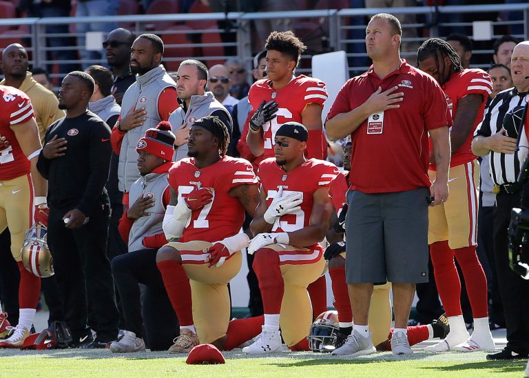 San Francisco 49ers outside linebacker Eli Harold, bottom center, and safety Eric Reid, bottom right, kneel during the national anthem before an NFL football game against the Arizona Cardinals in Santa Clara, Calif., Sunday, Nov. 5, 2017. (AP Photo/Jeff Chiu)