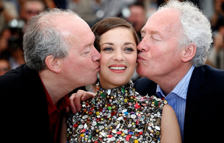 Director Jean-Pierre Dardenne, right, and director Luc Dardenne, left, kiss actress Marion Cotillard as they pose for photographers during a photo call for Two Days, One Night (Deux jours, une nuit) at the 67th international film festival, Cannes, southern France, Tuesday, May 20, 2014. (AP Photo/Alastair Grant)