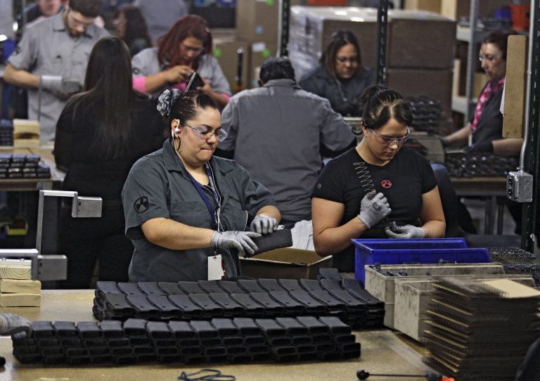 FILE - In this Feb. 28, 2013 file photo, workers assemble 30-round capacity ammunition magazines for high-velocity rifles, inside the Magpul Industries plant in Erie, Colo. Magpul, one of the country's largest producers of ammunition magazines for guns, is leaving Colorado and moving operations to Wyoming because of Colorado laws that include restrictions on how many cartridges a magazine can hold. The Wyoming State Loan and Investment Board is considering a $13 million incentive package to help Magpul make the move. (AP Photo/Brennan Linsley, File)