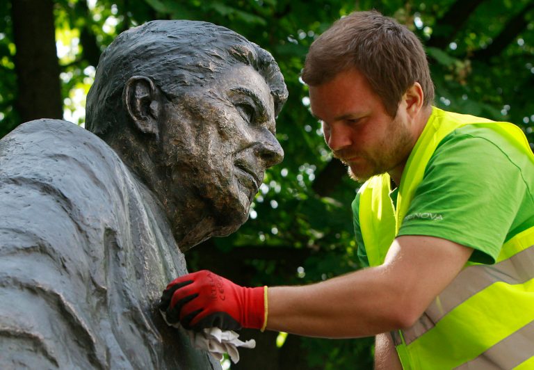 Cleaner Adam Gawronski polishes the bronze monument of former U.S. President Ronald Reagan in downtown Warsaw, Poland. (AP Photo/Czarek Sokolowski)