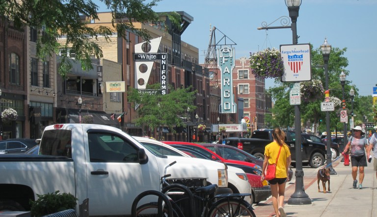 This photo shows pedestrians walking along Broadway in downtown Fargo, N.D. (AP Photo/Coralie Carlson)