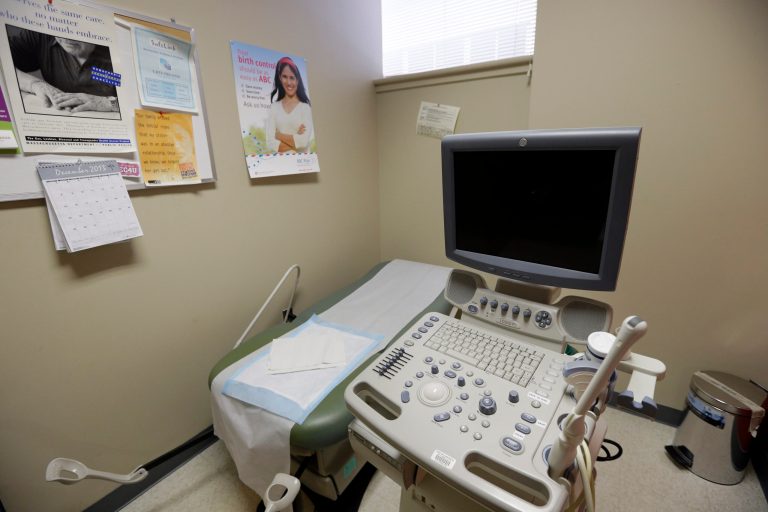 In this Tuesday, Dec. 17, 2013 photo posters line a wall in an ultrasound exam room at a Planned Parenthood location in Boston. (AP Photo/Steven Senne)