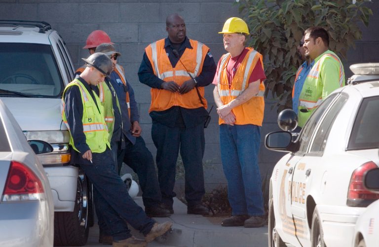 Advance Disposal workers wait outside of the company's facility Wednesday, Oct. 1, 2014, in Hesperia, Calif., as San Bernardino County Sheriff's deputies and detectives begin an investigation after a body of an infant was found in the trash and recycling sorting facility. (AP Photo/The Victor Valley Daily Press, James Quigg)