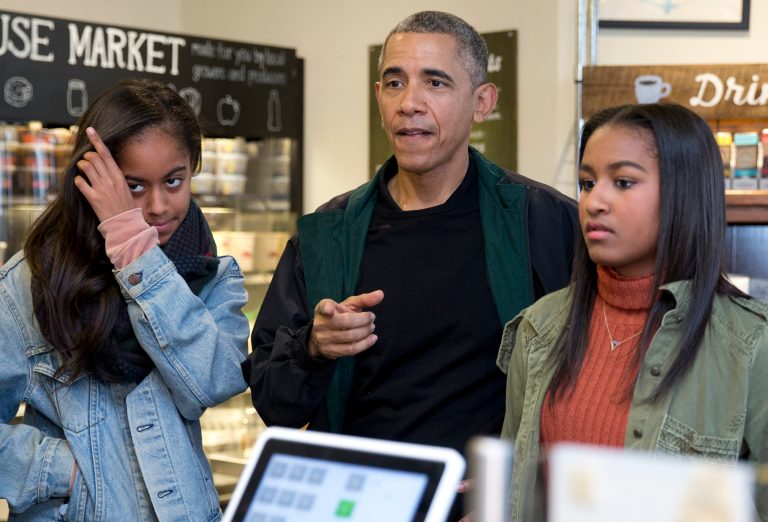 President Barack Obama, joined by his daughters Malia, left, and Sasha, right, orders ice cream at Pleasant Pops on Small Business Saturday in Washington. (AP Photo/Carolyn Kaster)