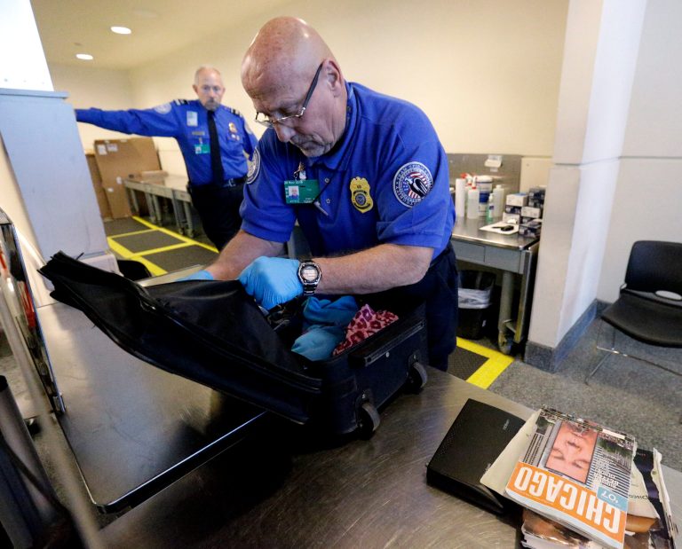 A TSA agent checks a bag at a security checkpoint area at Midway International Airport, Friday, Nov. 21, 2014, in Chicago. (AP Photo/Nam Y. Huh)