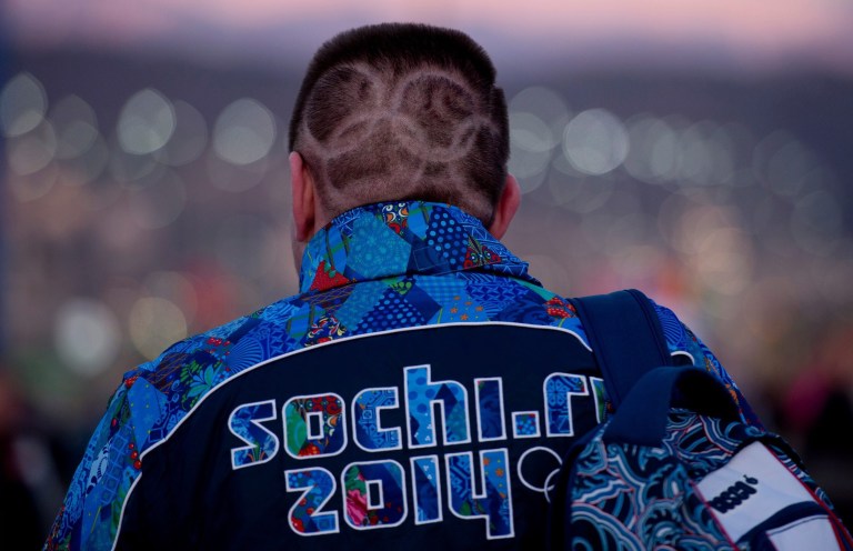 A Canadian fan with Olympic rings shaved into his hair makes his way to the opening ceremonies for the Sochi Winter Olympics Friday Feb. 7, 2014, in Sochi, Russia. (AP Photo/The Canadian Press, Adrian Wyld)
