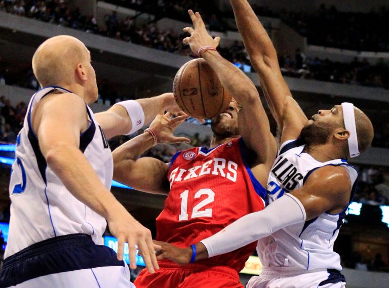   Philadelphia 76ers forward Evan Turner (12) is pressured by Dallas Mavericks center Chris Kaman (35) and guard Vince Carter (25) under the basket while trying to grab a rebound during the first half of an NBA basketball game, Tuesday, Dec. 18, 2012, in Dallas. (AP Photo/John F. Rhodes)  