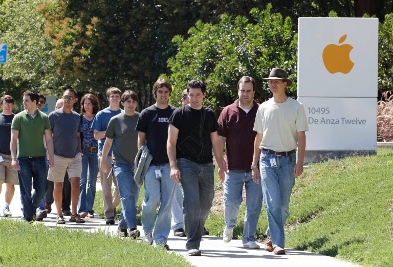 FILE - In this Aug. 25, 2011 file photo, Apple employees walk between buildings at Apple headquarters in Cupertino, Calif. A breakdown released Tuesday, Aug. 12, 2014 by Apple Inc. showed 54 percent of the company's technology jobs in the U.S. are handled by whites and another 23 percent by Asians. Men make up 80 percent of Apple's technology workforce throughout the world. (AP Photo/Paul Sakuma, File)