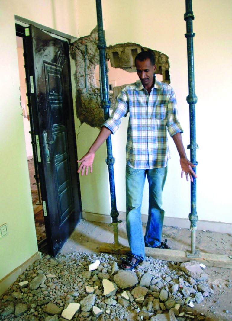 A Sudanese man shows damage in his home caused by an artillery shell in Khartoum, Sudan, in this Wednesday, Oct. 24, 2012 photo following an explosion and fire at a military factory south of the capital, Khartoum, killing at least two people as ammunition flew through the air. Senior Israeli officials on Thursday Oct 25 accused Sudan of playing a key role in an Iranian-backed network of arms shipments to hostile Arab militant groups across the Middle East. The tough comments are likely to fuel Sudanese allegations that Israel carried out the airstrike in the North African country's capital (AP Photo/Abd Raouf)