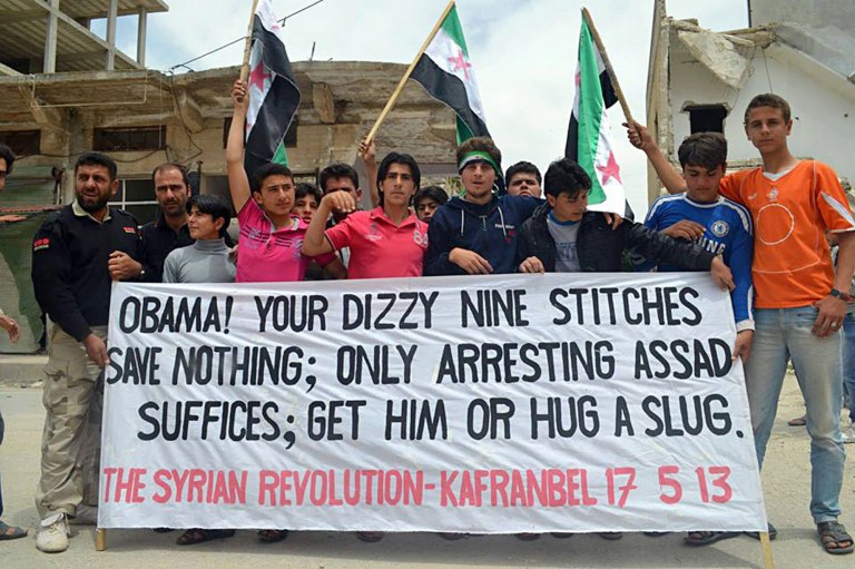 This citizen journalism image provided by Edlib News Network, ENN, which has been authenticated based on its contents and other AP reporting, shows anti-Syrian regime protesters carrying a banner during a demonstration in Kafr Nabil in Idlib province, northern Syria, Friday, May 17, 2013. Rights activists have found torture devices and other evidence of abuse in government prisons in the first Syrian city to fall to the rebels, Human Rights Watch said in a report Friday. (AP Photo/Edlib News Network ENN)