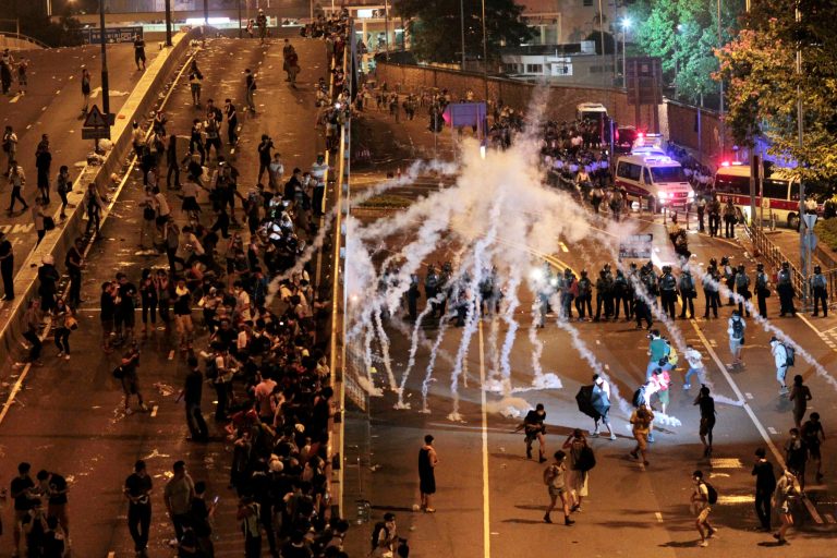 Riot police fire tear gas on student protesters occupying streets surrounding the government headquarters in Hong Kong, early Monday, Sept. 29, 2014. Riot police in Hong Kong on Saturday arrested scores of students who stormed the government headquarters compound during a night of scuffles to protest China's refusal to allow genuine democratic reforms in the semiautonomous city. (AP Photo/Wally Santana)