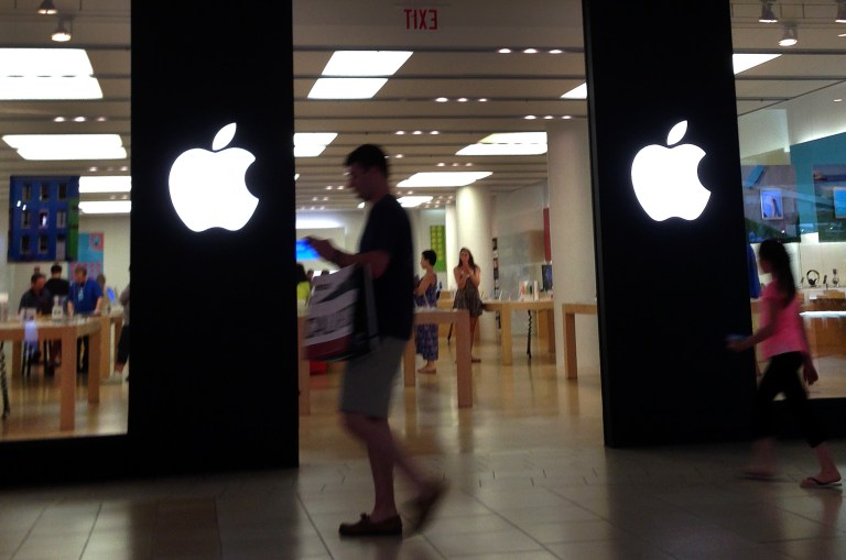 A shopper walks by an Apple store in Peabody, Mass., Monday, June 9, 2014. Apple's resurgent stock may have as much to do with financial engineering as the company's technological wizardry. In late April, the iPhone and iPad maker announced plans to split its stock for the first time in nine years. Since then, Apple's stock has climbed 23 percent, creating more than $100 billion in shareholder wealth while the Standard & Poor's 500 edged up just 4 percent. (AP Photo/Elise Amendola)