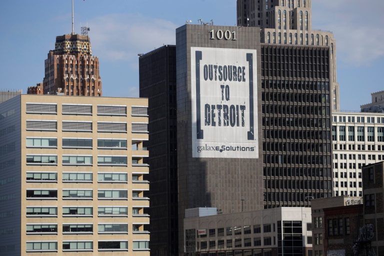 In this July 12, 2013, photo an Outsource to Detroit banner from Galaxe.Solutions is seen on a Detroit building. State-appointed emergency manager Kevyn Orr on Thursday, July 18, 2013, asked a federal judge permission to place Detroit into Chapter 9 bankruptcy protection. (AP/Carlos Osorio)