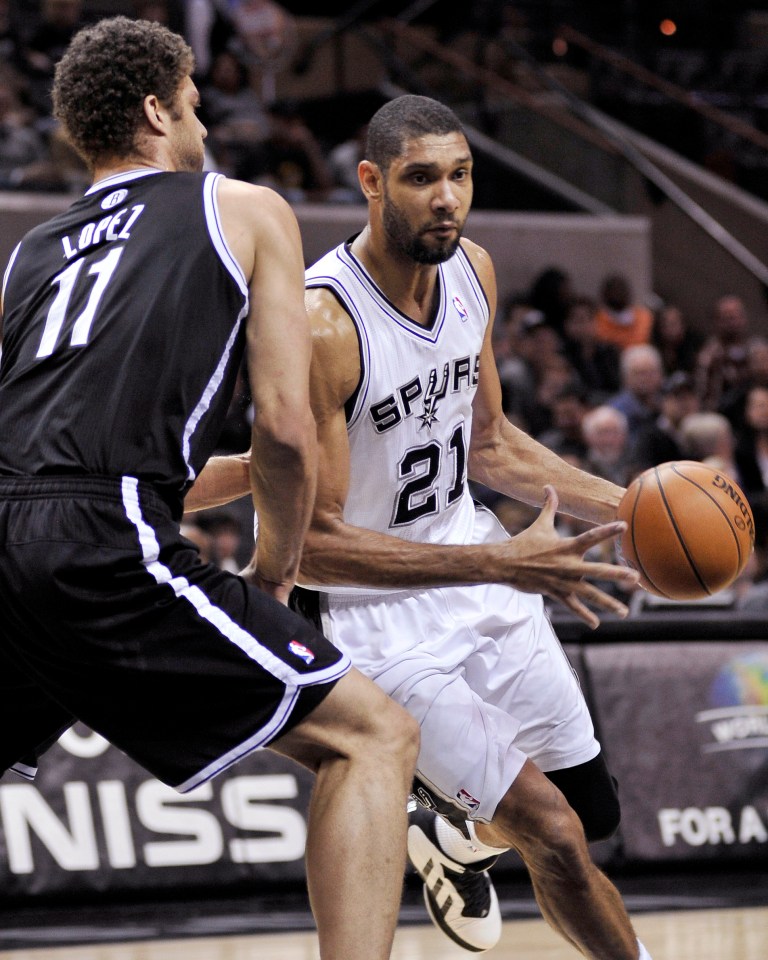   San Antonio Spurs' Tim Duncan (21) drives around Brooklyn Nets' Brook Lopez during the first half of an NBA basketball game, Monday, Dec. 31, 2012, in San Antonio. (AP Photo/Darren Abate)  