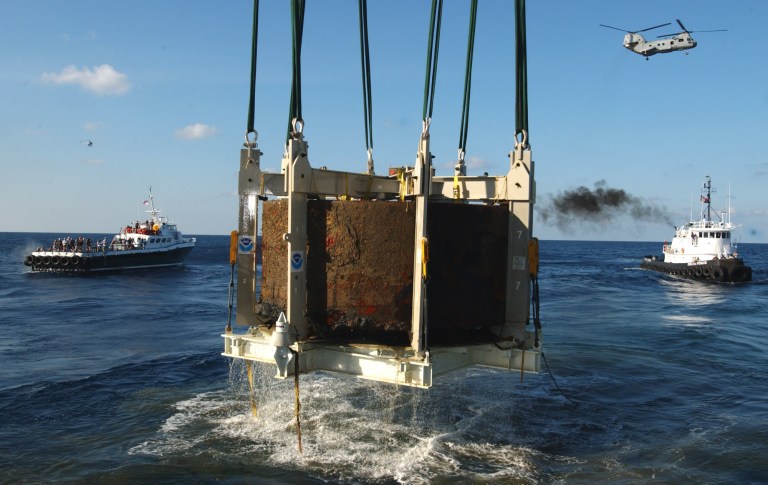 FILE This Monday Aug. 5, 2002 file photo shows the turret of the Civil War ironclad USS Monitor is lifted out of the ocean off the coast of Hatteras NC. A century and a half after the USS Monitor sank, the interment of remains of two unknown sailors found in the Civil War ironclad's turret is bringing together nearly 100 people from Maine to California who have a distant familial tie to the 16 Union sailors who died when the ship went down. (AP Photo/Steve Helber)
