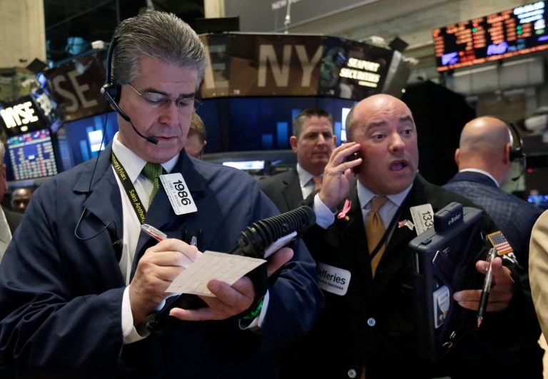 Traders Daniel Kryger, left, and Christopher Morie work on the floor of the New York Stock Exchange Wednesday, Aug. 6, 2014. Worries about Russian troops massing near the Ukrainian border are pushing stocks slightly lower. (AP Photo/Richard Drew)