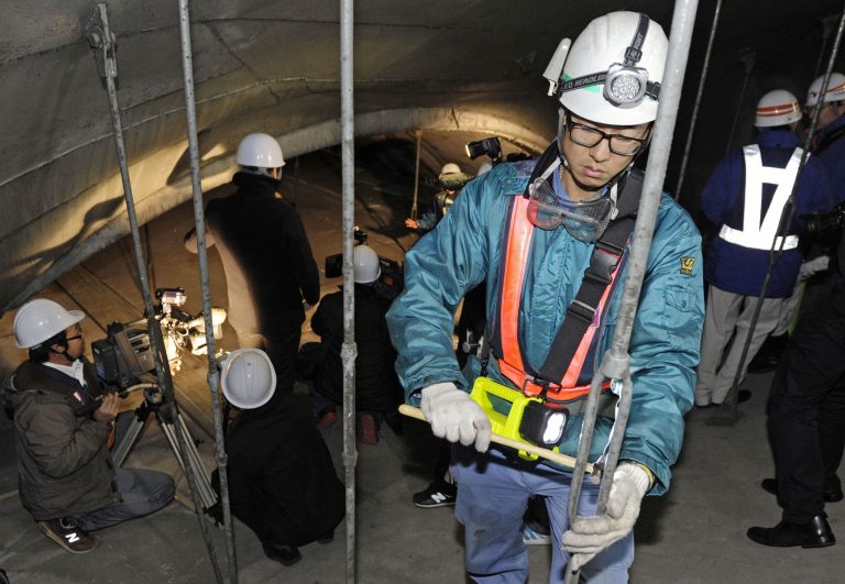   Workers inspect the structure inside the 1.65-kilometer (1-mile) Tsuburano Tunnel on the Tomei Expressway in Yamakitamachi, Kanagawa Prefecture, eastern Japan, Monday, Dec. 3, 2012. Concrete ceiling panels fell onto moving vehicles deep inside a tunnel on another expressway in Japan Sunday, and authorities confirmed nine deaths before suspending rescue work Monday while the roof was being reinforced to prevent more collapses. (AP Photo/Kyodo News) JAPAN OUT, MANDATORY CREDIT, NO LICENSING IN CHINA, FRANCE, HONG KONG, JAPAN AND SOUTH KOREA  