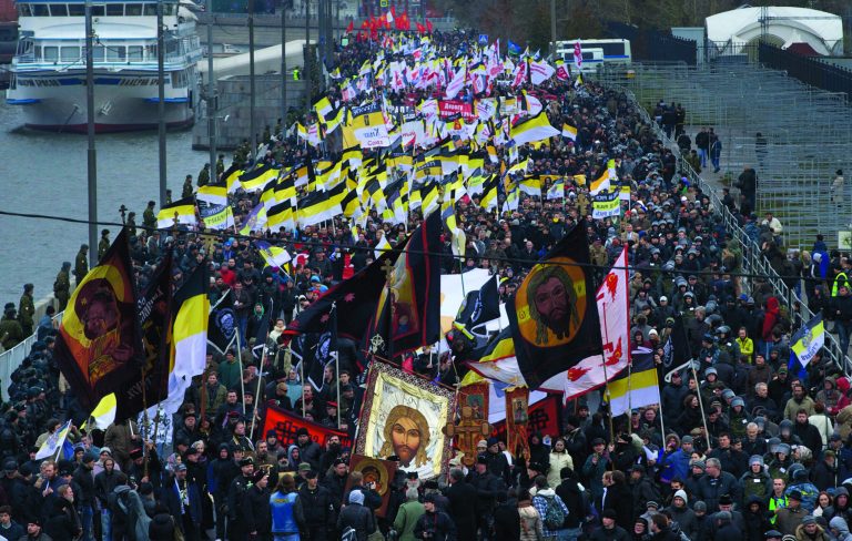 Ultra nationalist demonstrators and activists march carrying the Russian Empire's black-yellow-white flags to mark National Unity Day, on the outskirts of Moscow, Sunday, Nov. 4, 2012. Chanting 