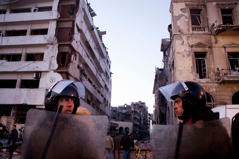 FILE - In this file photo taken Tuesday, Dec. 24, 2013, Egyptian policemen stand guard at the scene of a powerful explosion, believed to be a car bomb, at a police headquarters building that killed at least a dozen people, wounded more than 100, and left scores buried under the rubble, in the Nile Delta city of Mansoura, 110 kilometers (70 miles) north of Cairo, Egypt. On Saturday May 10, 2014. Egypt's chief prosecutor's office says it has charged 200 suspected militants with carrying out terrorist attacks that killed 40 policeman and 15 civilians, and of conspiring with al-Qaida and the Palestinian militant group Hamas in one of the country's largest terrorism-related cases. (AP Photo/Ahmed Ashraf, File)