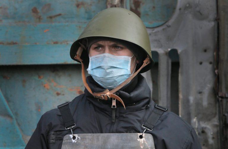 An opposition supporter stands at a police barricade near the Presidential office in Kiev, Ukraine, Friday, Feb. 21, 2014. Ukraine's president gave in to pressure from European diplomats and offered concessions Friday to defuse a crisis that has divided his country and left scores dead. Shots rang out near Kiev's protest camp and protesters fought among themselves about what to do next. (AP Photo/Efrem Lukatsky)