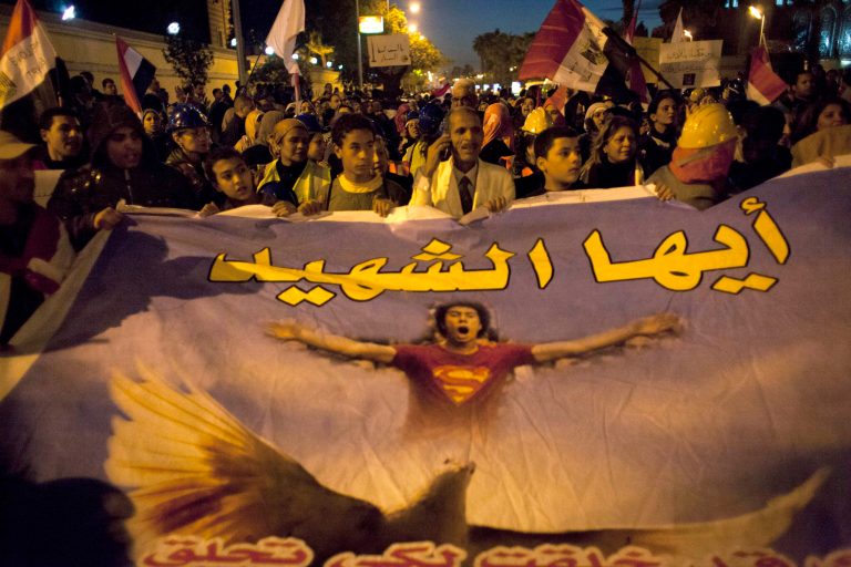   Protesters opposing Egyptian president Mohammed Morsi carry national flags and a poster that reads in Arabic 