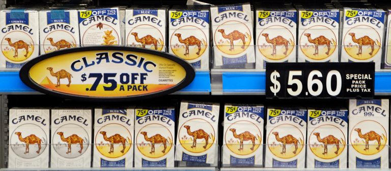 In this June 6, 2014 photo, packs of Camel cigarettes, a Reynolds American brand, are displayed at the Bi-Rite market in Olmsted Falls, Ohio. Reynolds American Inc. on Tuesday, July 29, 2014 said that its profit rose by 6.7 percent in its second quarter as higher cigarette and smokeless tobacco prices helped to offset a decline in the number of cigarettes it sold. (AP Photo/Mark Duncan)
