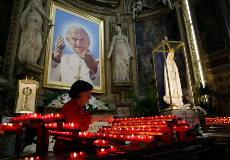 A picture of late Pope John Paul II is displayed inside St. Sprit in Sassia church during a mass in Rome, Wednesday, April 23, 2014. Hundred thousands of pilgrims and faithful are expected to reach Rome to attend the scheduled April 27 ceremony at the Vatican in which Pope Francis will elevate in a solemn ceremony John XXIII and John Paul II to sainthood. (AP Photo/Gregorio Borgia)