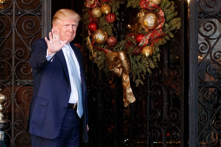President-elect Donald Trump stands at the entrance of Mar-a-Lago and waves to reporters after meeting with Carlyle Group co-founder and co-CEO David Rubenstein, Wednesday, Dec. 28, 2016, in Palm Beach, Fla. (AP Photo/Evan Vucci)