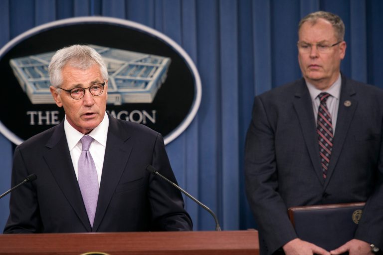 Defense Secretary Chuck Hagel, accompanied by Deputy Defense Secretary Bob Work, briefs reporters at the Pentagon, Wednesday, Oct. 1, 2014, on the military health care system. (AP Photo/Cliff Owen)
