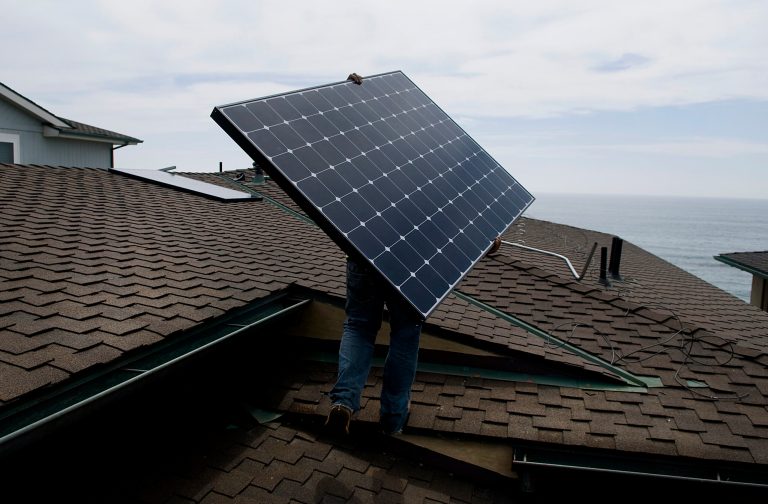 Juan Moedano, an installer for Stellar Solar, carries a solar panel during installation at a home in Encinitas, California, U.S., on Wednesday, Aug. 15, 2012. Stellar Solar installs residential and commercial solar panels in the San Diego area. Photographer: Sam Hodgson/Bloomberg *** Local Caption *** Juan Moedano