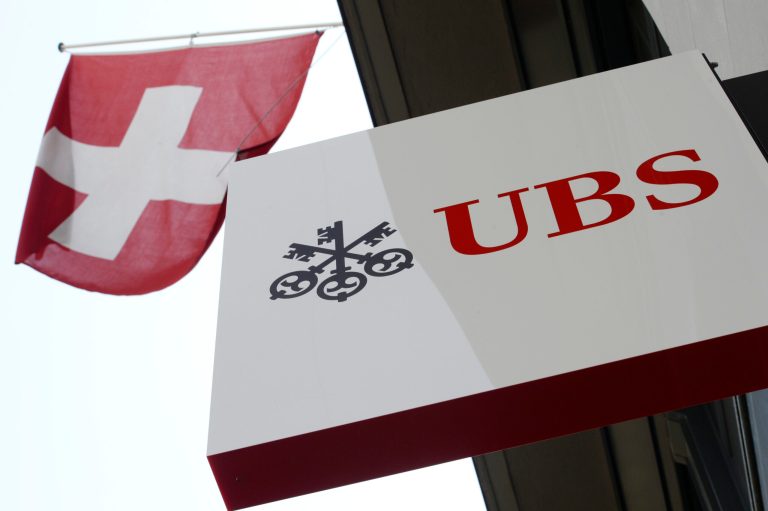 FILE - The April 24, 2014 file photo shows the logo of Swiss bank UBS and the Swiss flag in Zurich, Switzerland. Swiss banking giant UBS AG reported a 15 percent jump Tuesday July 29, 2014  in second-quarter net profit from a year ago, driven by strong results from its core wealth management and trimmed-down investment banking franchises despite a tough market environment.  Switzerland's biggest bank said its net profit for the April-June period rose to 792 million Swiss francs (US$ 876 million), up from 690 million francs in the comparable period from 2013. (AP Photo/Keystone, Steffen Schmidt,File)