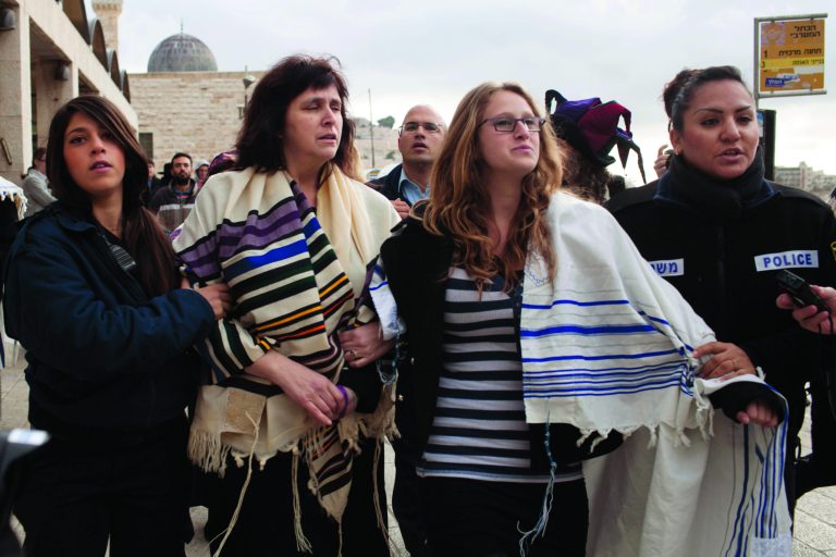 Wrapped in Jewish prayer shawls, Rabbi Susan Silverman, second left, the sister of comedian Sarah Silverman, not seen, along with her teenage daughter Hallel Abramowitz, second right, are detained by police officers in Jerusalem's Old City, Monday, Feb. 11, 2013. The head of the Women of the Wall organization, a liberal Jewish women's group, said 10 women were detained for wearing religious garb which Orthodox Judaism reserves for men only. About 300 people gathered at the Western Wall Monday to protest the Orthodox Jewish control of the site. (AP Photo/Tali Mayer)