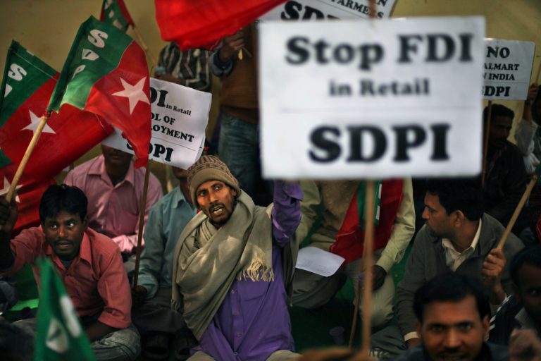   Supporters of Socialist Democratic Party of India hold placards during a protest against allowing foreign investment in the retail sector in New Delhi, India, Wednesday, Dec. 5, 2012. Indian lawmakers on Wednesday debated the government's decision to open up the country's huge retail sector to foreign big-box companies like Wal-Mart, a move that opponents say will crush small shop owners and farmers. (AP Photo/Altaf Qadri)  