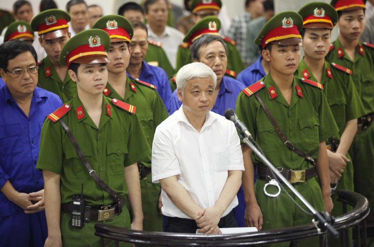 Nguyen Duc Kien, center, former vice chairman of the founding council of the Asia Commercial Bank (ACB), appears at the Hanoi People's Court in Hanoi, Vietnam, Monday, June 9, 2014. The court sentenced Kien, one of the country's richest men,  to 30 years in prison on Monday after finding him guilty of financial crimes involving millions of dollars. Kien, a flamboyant businessman who also headed the Hanoi ACB football club, was arrested in 2012. The move was seen as part of the fallout of a power struggle among factions in the ruling Communist Party and allied business tycoons. (AP Photo/VNA Photo, Doan Tan) VIETNAM OUT