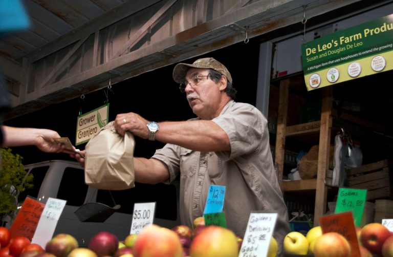In this Sept. 18, 2014 photo, Douglas De Leo hands customers a bag of produce at the Kalamazoo Farmers Market in Kalamazoo, Mich. The Conference Board releases the Consumer Confidence Index for September on Tuesday, Sept. 30, 2014. (AP Photo/Kalamazoo Gazette-MLive Media Group, Katie Alaimo) ALL LOCAL TELEVISION OUT; LOCAL TELEVISION INTERNET OUT