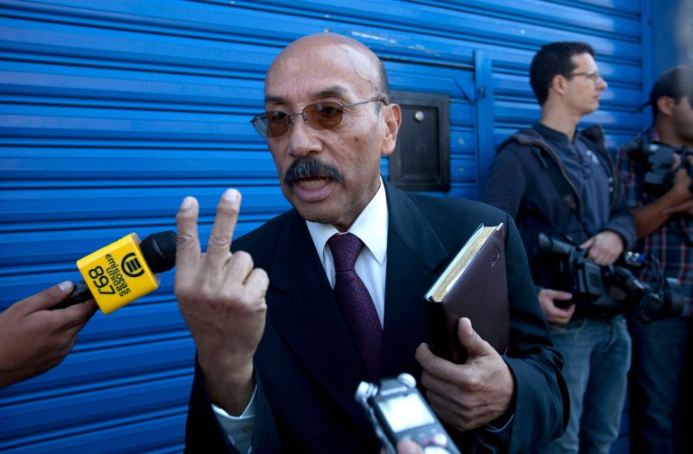   Telesforo Guerra, the lawyer of software company founder John McAfee, speaks to journalist outside the detention immigration center where McAfee is being held, in Guatemala City, Friday, Dec. 7, 2012. Guerra told reporters that the creator of the McAfee antivirus program is in good health, and his team is filing four separate legal appeals in an effort to prevent his return to Belize. (AP Photo/Moises Castillo)  