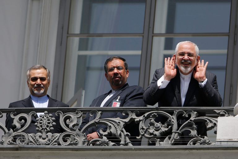 Iranian Foreign Minister Mohammad Javad Zarif, right, gestures to journalists from a balcony with other members of his delegation, outside of the current round of Iran nuclear talks, being held in Vienna, Austria July 10, 2015. (AP Photo)Â 
