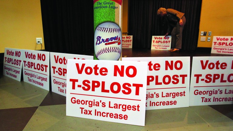 Debbie Dooley, co-founder of the Atlanta Tea Party, sets out signs and waits for returns where T-SPLOST opposition groups gather for a election night watch at Hudson Grille in Atlanta on Tuesday, July 31, 2012. Gov. Nathan Deal and Atlanta Mayor Kasim Reed are making an 11th-hour push to Georgia voters to approve the transportation tax referendum on Tuesday's primary ballot. Critics blast the plan _ the first statewide referendum in Georgia history _ as not only the heftiest tax proposal in state history, but as a false strategy that they say addresses neither sprawl nor smart growth. (AP Photo/Atlanta Journal-Constitution, Curtis Compton)