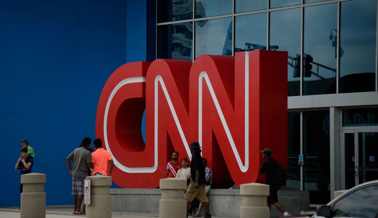 Pedestrians pass in front of CNN signage displayed at the network's headquarters in Atlanta, Georgia.