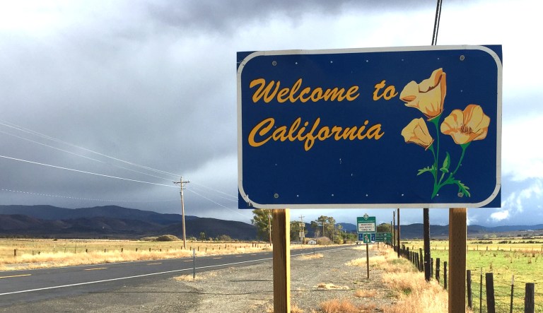 A "Welcome to California" sign is shown near the California-Nevada border.