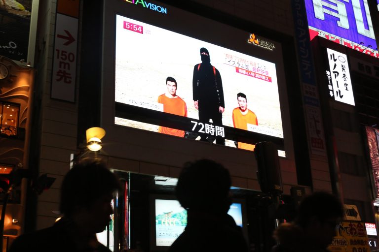A news program reports on two Japanese hostages held by the Islamic State of Iraq and Syria, in Tokyo on Friday, Jan. 23, 2015. (AP Photo/Eugene Hoshiko)